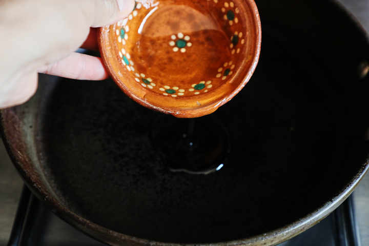 Verter ¼ de taza de aceite de cocina en una sartén.