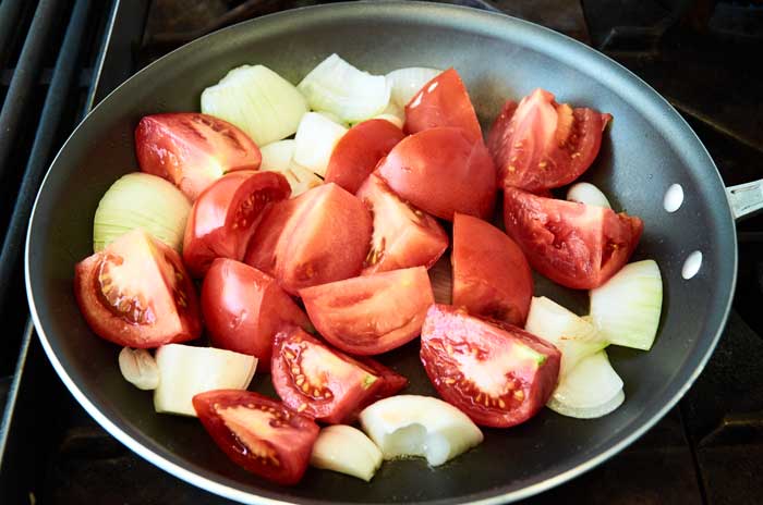 Freír tomates y cebollas